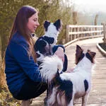Portrait en plein air d’une jeune femme avec ses deux chiens – photo lifestyle naturelle