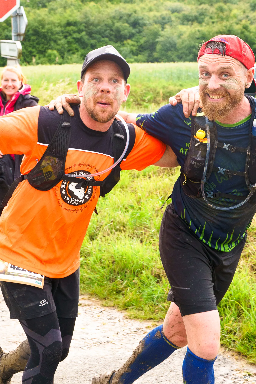 Deux amis complices lors d’un trail boueux, immortalisés en photo lifestyle sportive