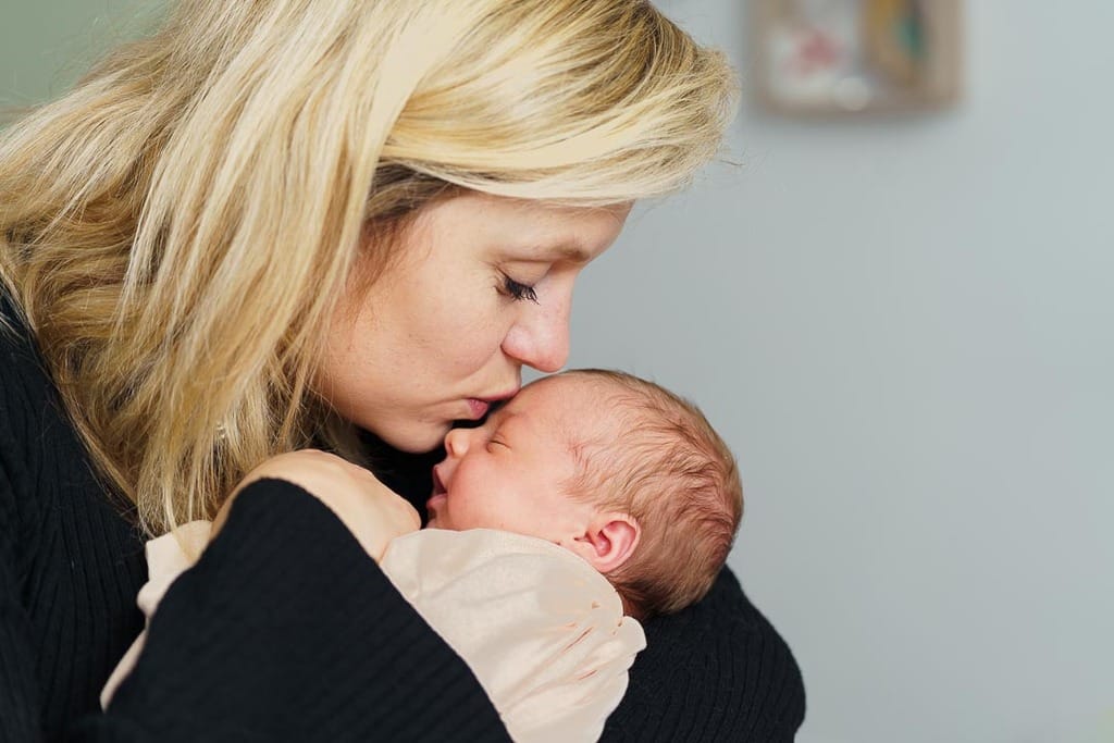 moment de douceur entre une mère et son bébé, pris en photo lors d'une séance de nouveau-né